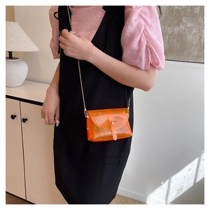Detail showing orange transparent PVC mini bag with gold chain and metal buckle
