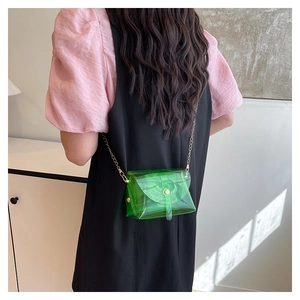 Détail du sac gelée vert transparent avec chaîne dorée porté en sac bandoulière