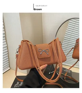 Close-up of brown woven baguette bag featuring a silver metal bow buckle detail