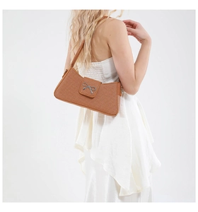 Vue détaillée du sac baguette marron avec nœud en métal argenté et finition texturée