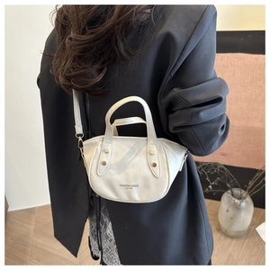 Detailed view of beige PU leather bucket bag with top handle and metal strap hooks