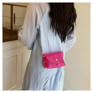 Detailweergave van een transparante felle roze jelly crossbodytas met gouden ketting