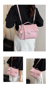 Detail of pink quilted tote bag showing rhombus stitching and metal turn-lock closure