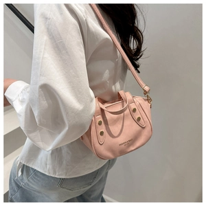 Close-up of pink ruched bucket bag with gold rivets and FASHION & BAGS logo detail