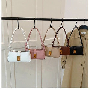 Detail view of five matte leather underarm bags with knot handles and bronze metal locks