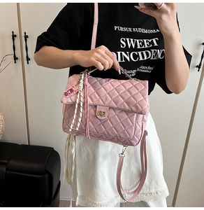 Detail of pink quilted tote bag showing diamond texture and stylish tassel charm