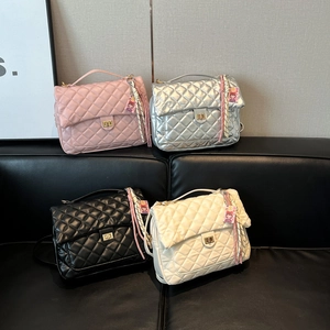 Classic diamond quilted tote bags in pink silver black and cream on leather sofa