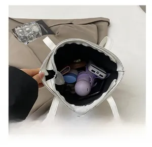Vue de dessus montrant l'intérieur spacieux du cabas avec un parapluie et un téléphone