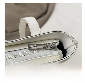 Gros plan de la fermeture éclair et des coutures sur un sac blanc en cuir ciré