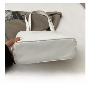 Détail du fond résistant à l'usure et des coutures renforcées du grand sac fourre-tout argenté