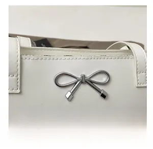 Détail du nœud en métal argenté sur un sac fourre-tout en cuir blanc cassé de luxe