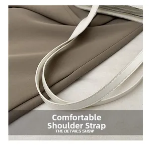 Détail de la bandoulière en cuir blanc souple avec double couture sur le sac cabas