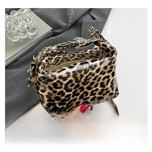 Detail of leopard print glossy PU leather handbag with metallic zipper and buckles