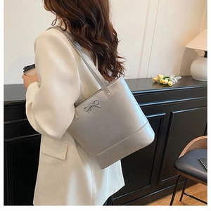 Détail du sac cabas gris avec nœud métallique et finition élégante en cuir synthétique