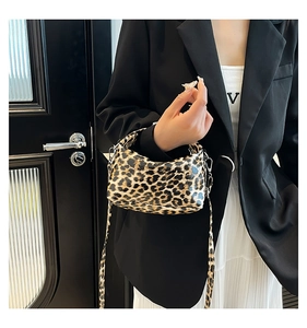 Detail of leopard print handbag featuring a silver metal buckle and detachable strap