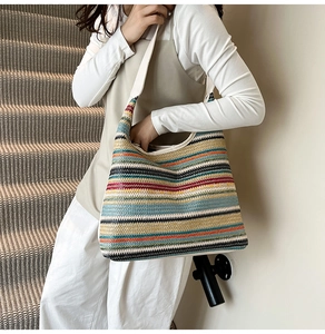 Detail shot of colorful woven hobo bag with striped texture and white shoulder strap