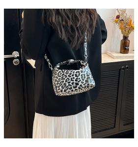 Detail of leopard print crossbody bag with silver metal lock and stylish trapezoid shape