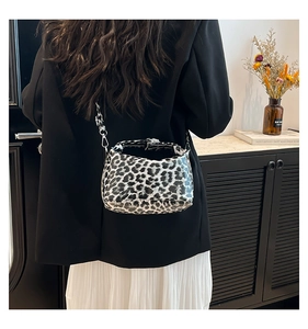 Detailed view of the black and white leopard print baguette bag with a silver chain link