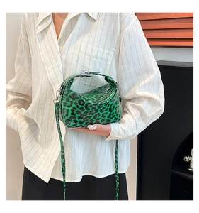 Close-up of green leopard print tote bag with glossy finish and silver metal hardware