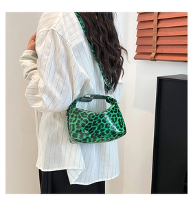 Green leopard print patent leather underarm bag worn with a white striped shirt