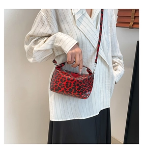 Detail of red and black leopard print shoulder bag with shiny patent leather texture