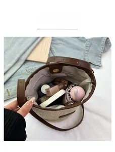 Detailed view of straw bucket bag interior with leather trim and herringbone lining