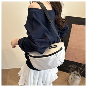 Detail of white nylon crescent bag showing the black adjustable strap and fashion label