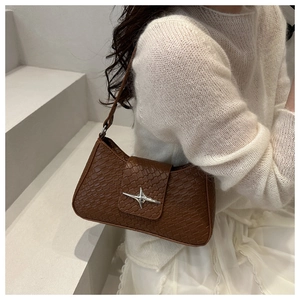 Close-up of brown crocodile texture leather bag featuring a silver star-shaped buckle