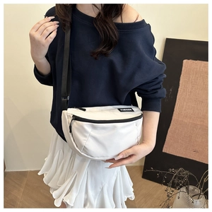 Detail of white nylon crescent bag with FASHION patch and adjustable black strap