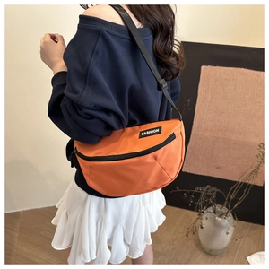 Detail of orange nylon crossbody bag with Fashion logo and adjustable black strap