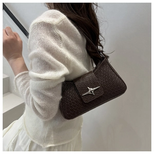 Detail of dark brown faux crocodile baguette bag with a silver star buckle on model