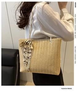 Détail du sac cabas en paille avec foulard en soie à motif chaîne sur la poignée