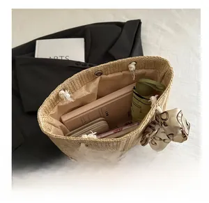 Macro view of beige straw tote bag interior showing large capacity and silk scarf detail