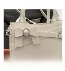 Détail du sac à main en cuir blanc avec un nœud élégant et une boucle en métal argenté