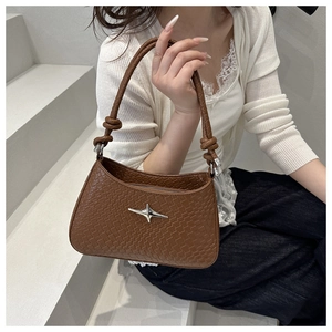 Detail of brown woven leather shoulder bag with silver star buckle and knotted strap