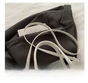 Détail de la bandoulière du sac en cuir blanc avec sa boucle en métal argenté élégante