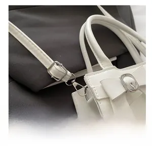 Détail de la boucle en métal argenté et de la bandoulière réglable sur le sac blanc en PU