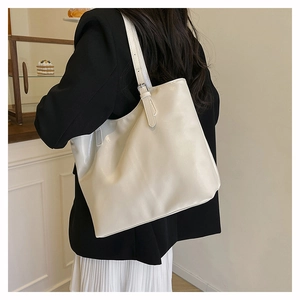 Detail of off-white PU leather tote bag with adjustable metal buckle on shoulder strap