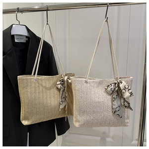 Détail de sacs fourre-tout en paille tissée à la main avec foulards en soie décoratifs