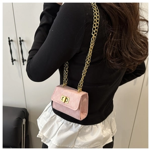 Pink mini square bag featuring a thick gold chain strap and metallic twist lock on model