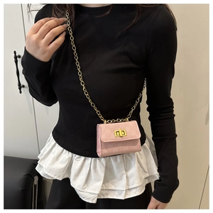 Close-up of pink mini chain crossbody bag featuring gold twist lock and lychee texture