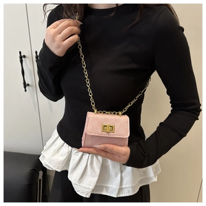 Detailed view of pink mini chain crossbody bag with golden rectangular turn-lock closure