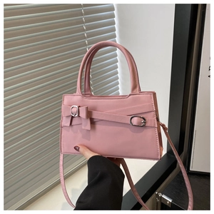 Détail du sac rose avec nœud décoratif, boucle en métal et fine bandoulière réglable