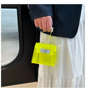 Detalle de mini bolso jelly amarillo neón con cierre plateado y correa de cadena metálica