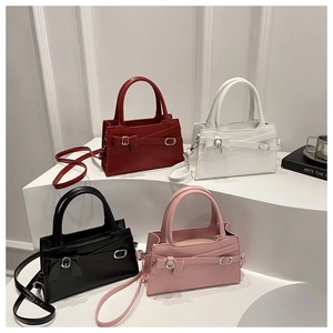 Sacs bandoulière à nœud en rouge, blanc, noir et rose sur présentoirs blancs