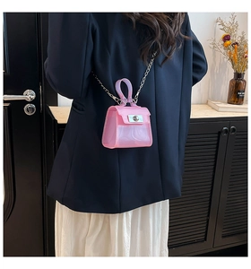 Close-up of pink transparent PVC jelly bag with silver clasp and metal chain strap