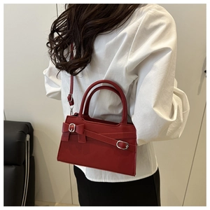 Sac à main rouge à nœud porté par un mannequin pour montrer la vue arrière et taille