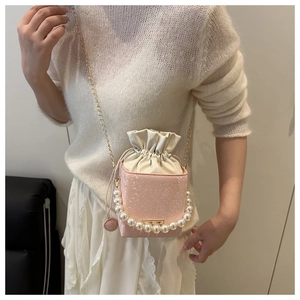 Pink heart-textured bucket bag with pearl handle and golden chain on a model