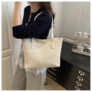 Close-up of beige woven tote bag showing fine V-shaped texture and white long handle