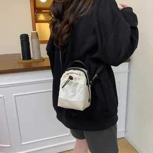 Minimalist drawstring crossbody bucket bag in cream and khaki nylon for a stylish casual look